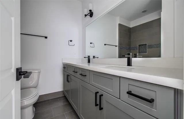 a bathroom with a sink a toilet a mirror and vanity