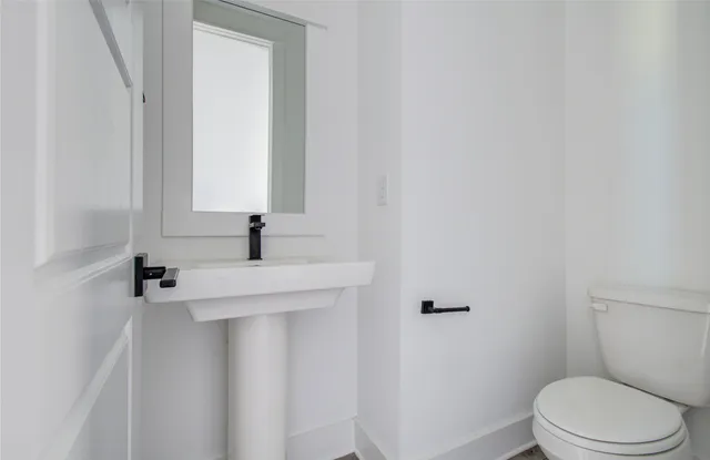 a bathroom with a sink a toilet and mirror