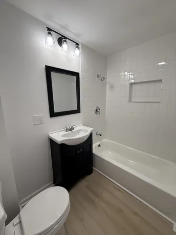 a bathroom with a sink mirror vanity and toilet