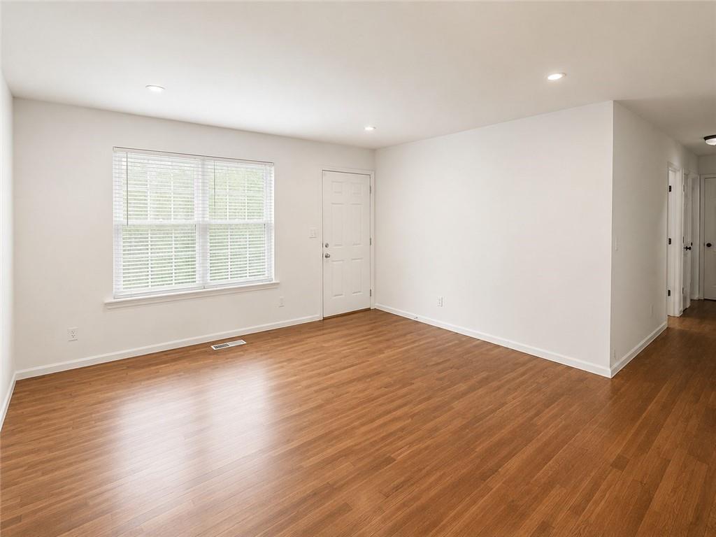1929 Wee Kirk Road Southeast Atlanta, GA 30316 - Photo 4 of 22 an empty room with wooden floor and windows