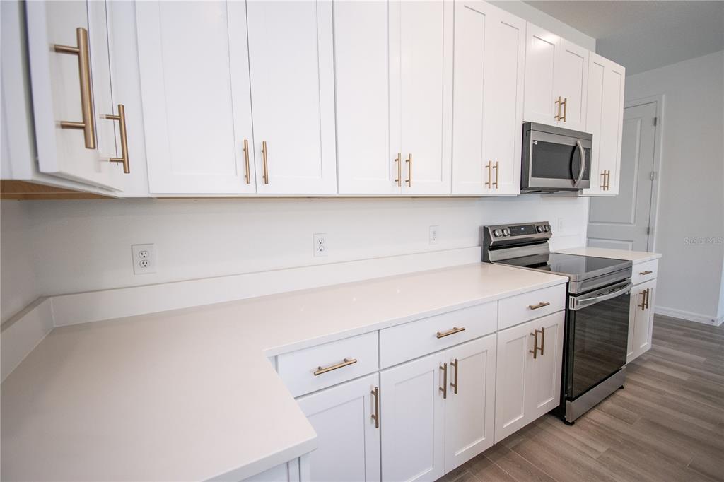 947 Conch Road Davenport, FL 33896 - Photo 6 of 20 a kitchen with white cabinets and white appliances