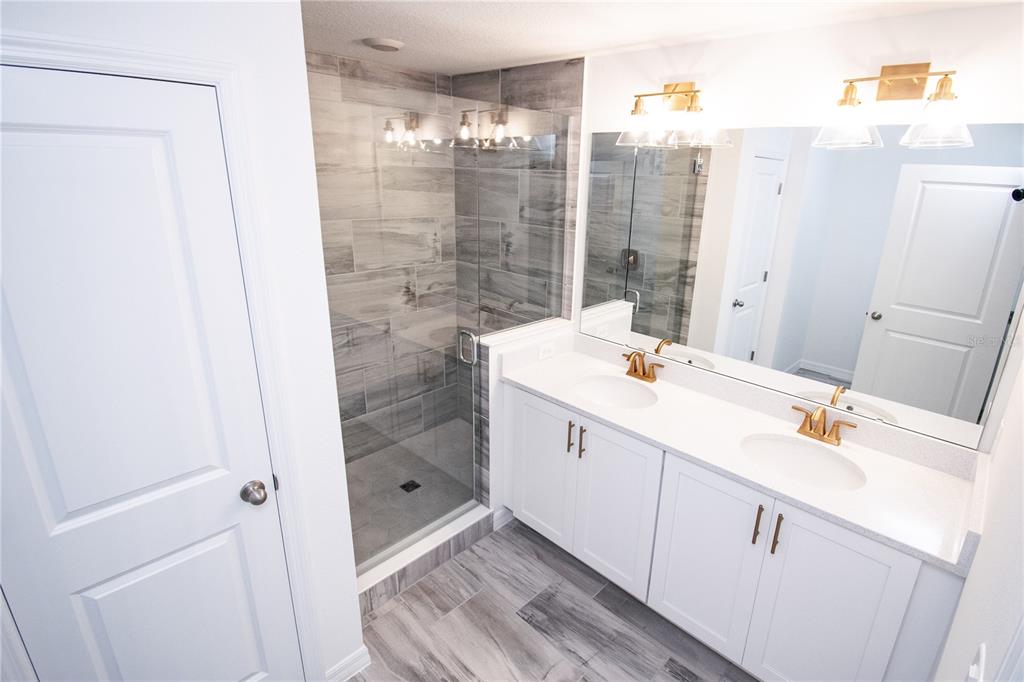 947 Conch Road Davenport, FL 33896 - Photo 9 of 20 a bathroom with a shower sink and mirror