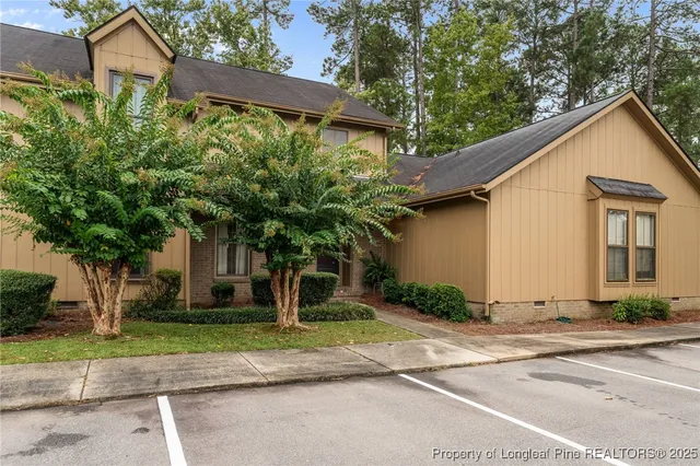 a front view of a house with a yard and trees