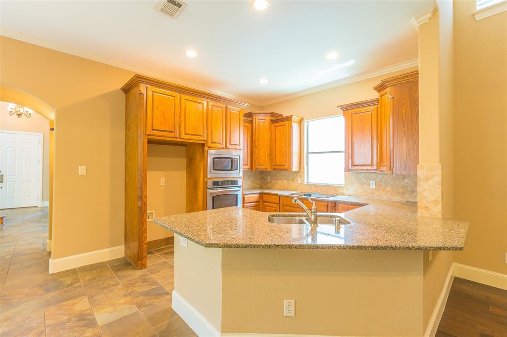 7804 Keechie Drive McKinney, TX 75070 - Photo 14 of 39 a kitchen with stainless steel appliances granite countertop a sink and a refrigerator