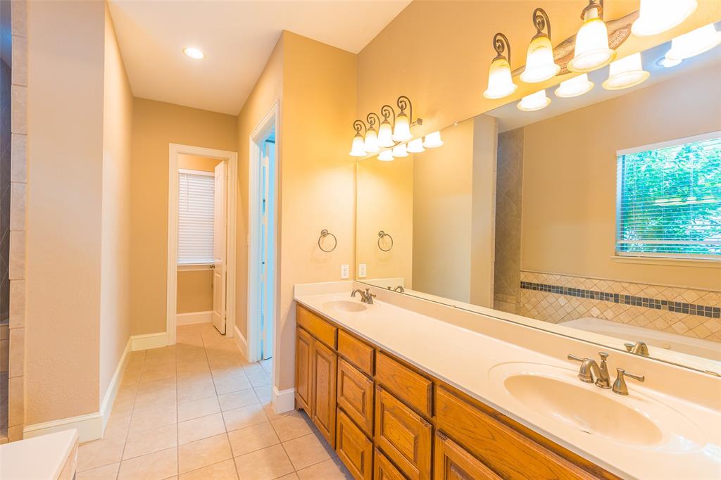7804 Keechie Drive McKinney, TX 75070 - Photo 22 of 39 a spacious bathroom with a double vanity sink a mirror and a shower