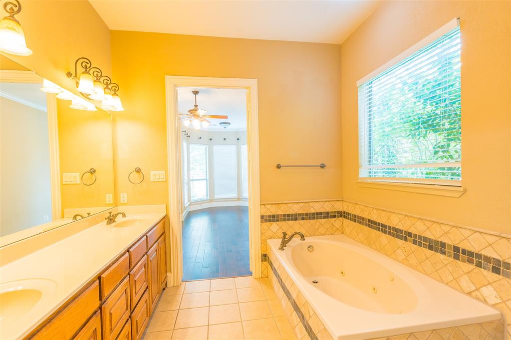 7804 Keechie Drive McKinney, TX 75070 - Photo 24 of 39 a spacious bathroom with a tub sink and mirror