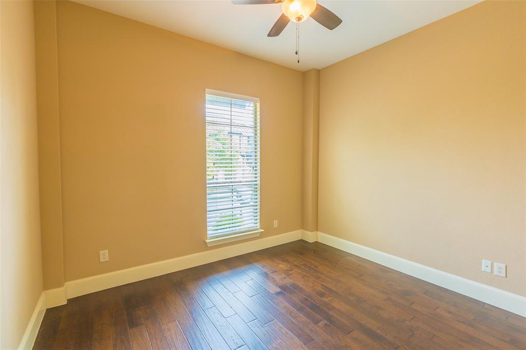 7804 Keechie Drive McKinney, TX 75070 - Photo 25 of 39 an empty room with wooden floor chandelier fan and windows