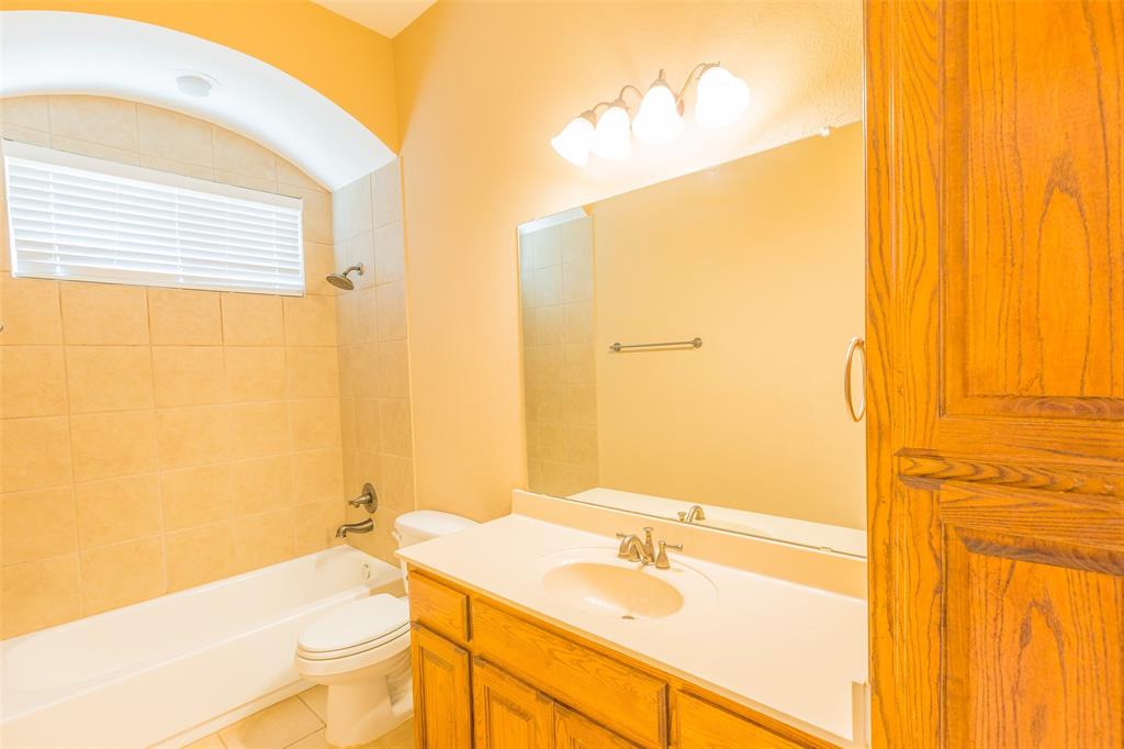 7804 Keechie Drive McKinney, TX 75070 - Photo 27 of 39 a bathroom with a granite countertop sink and a mirror
