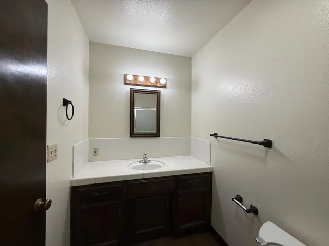 a bathroom with a sink toilet and mirror