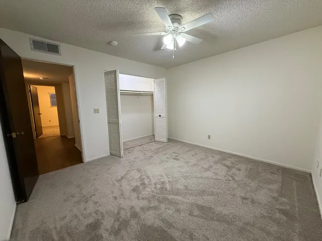 a view of a big room with closet and a chandelier fan