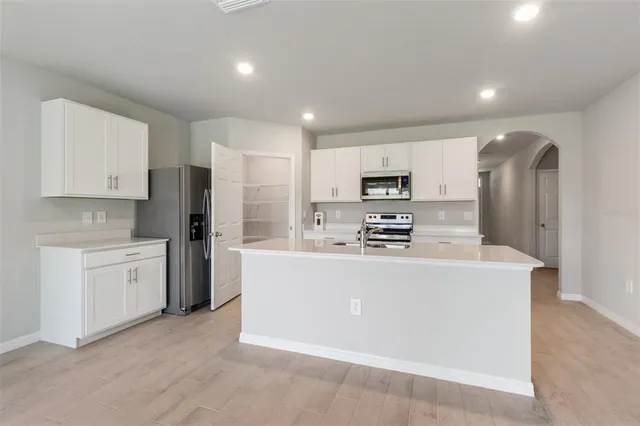 a large kitchen with cabinets and stainless steel appliances
