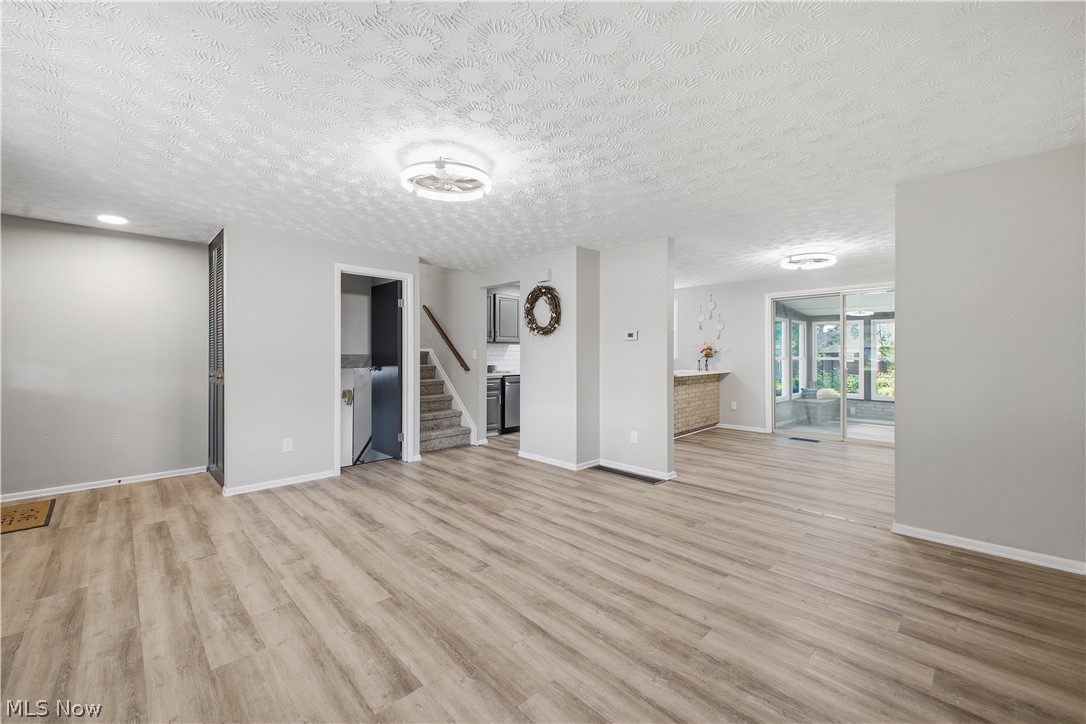 4845 New Road Austintown, OH 44515 - Photo 11 of 40 Wood-finish flooring throughout, light gray wall tones, ceiling-mounted lighting fixtures, and a staircase with carpeted treads