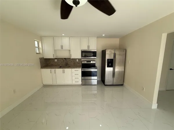 a kitchen with stainless steel appliances kitchen island a refrigerator and a stove top oven