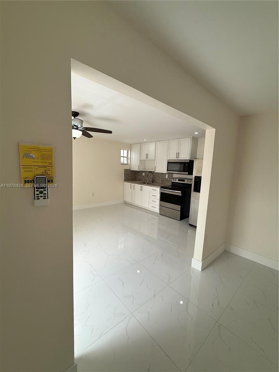 11690 Southwest 185th Street, Unit 1 Miami, FL 33157 - Photo 5 of 11 a view of kitchen with refrigerator stove and cabinets