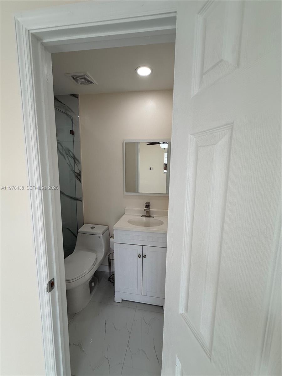 11690 Southwest 185th Street, Unit 1 Miami, FL 33157 - Photo 7 of 11 a bathroom with a sink a toilet and shower