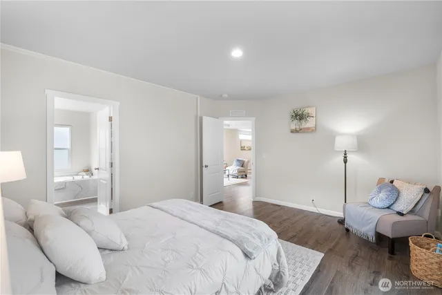 a spacious bedroom with a bed and a lamp