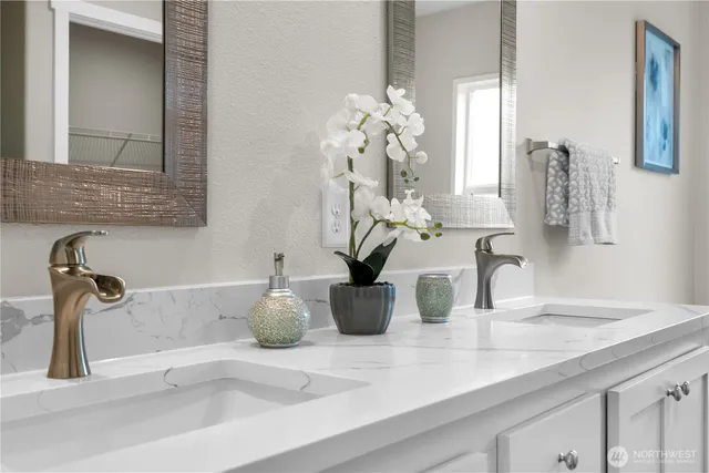 a bathroom sink with a granite countertop mirror and vanity