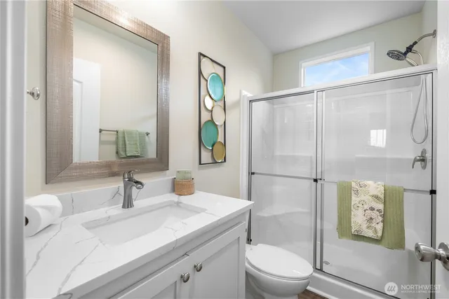 a bathroom with a granite countertop sink toilet a mirror and shower