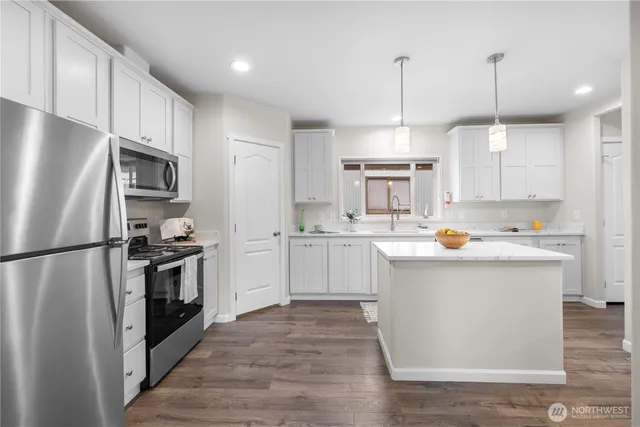 a kitchen with white cabinets stainless steel appliances and a island