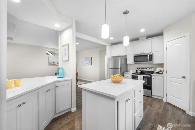 a kitchen with white cabinets and stainless steel appliances