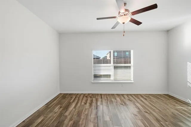 an empty room with a window and a fan