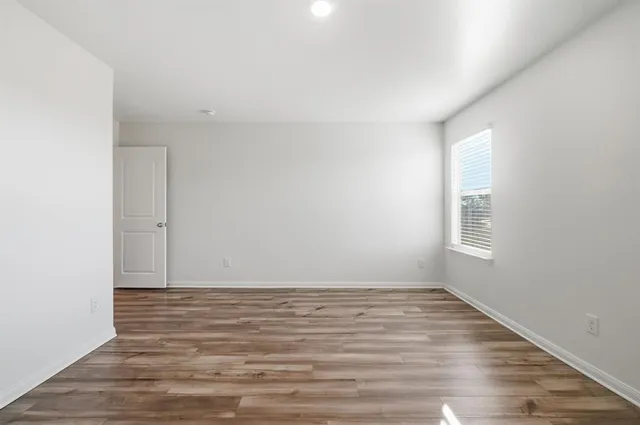 a view of room with window and wooden floor