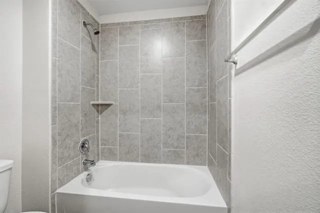 a white bath tub sitting next to a shower