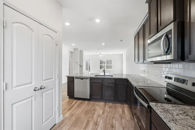 a kitchen with stainless steel appliances granite countertop a sink stove and refrigerator