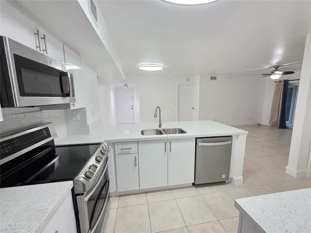 an empty room with windows and ceiling fan