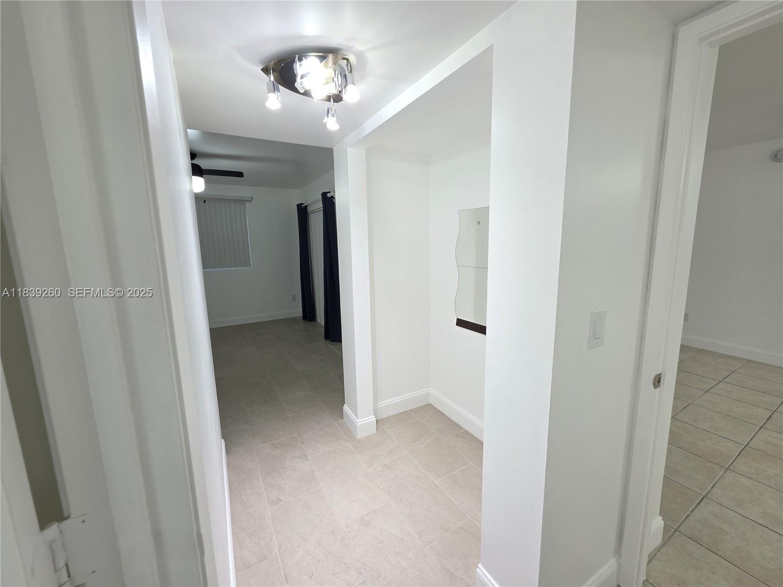 2620 South University Drive, Unit 111 Davie, FL 33328 - Photo 25 of 49 a view of a hallway with a chandelier fan