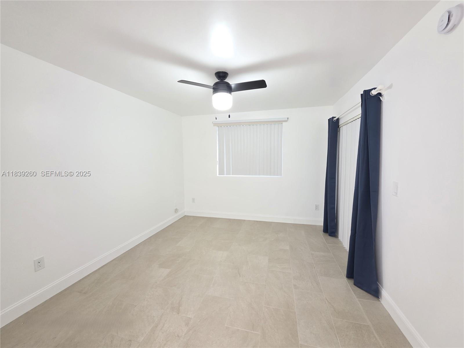 2620 South University Drive, Unit 111 Davie, FL 33328 - Photo 27 of 49 an empty room with windows and ceiling fan