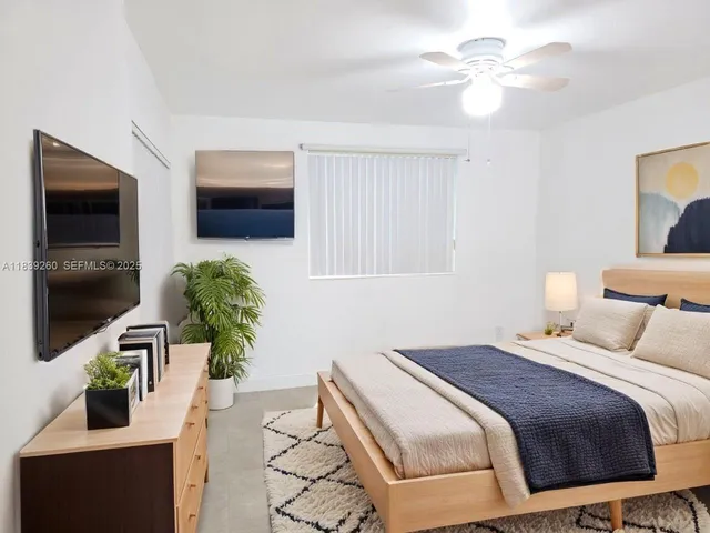a bedroom with a bed potted plants on the dresser and a chandelier