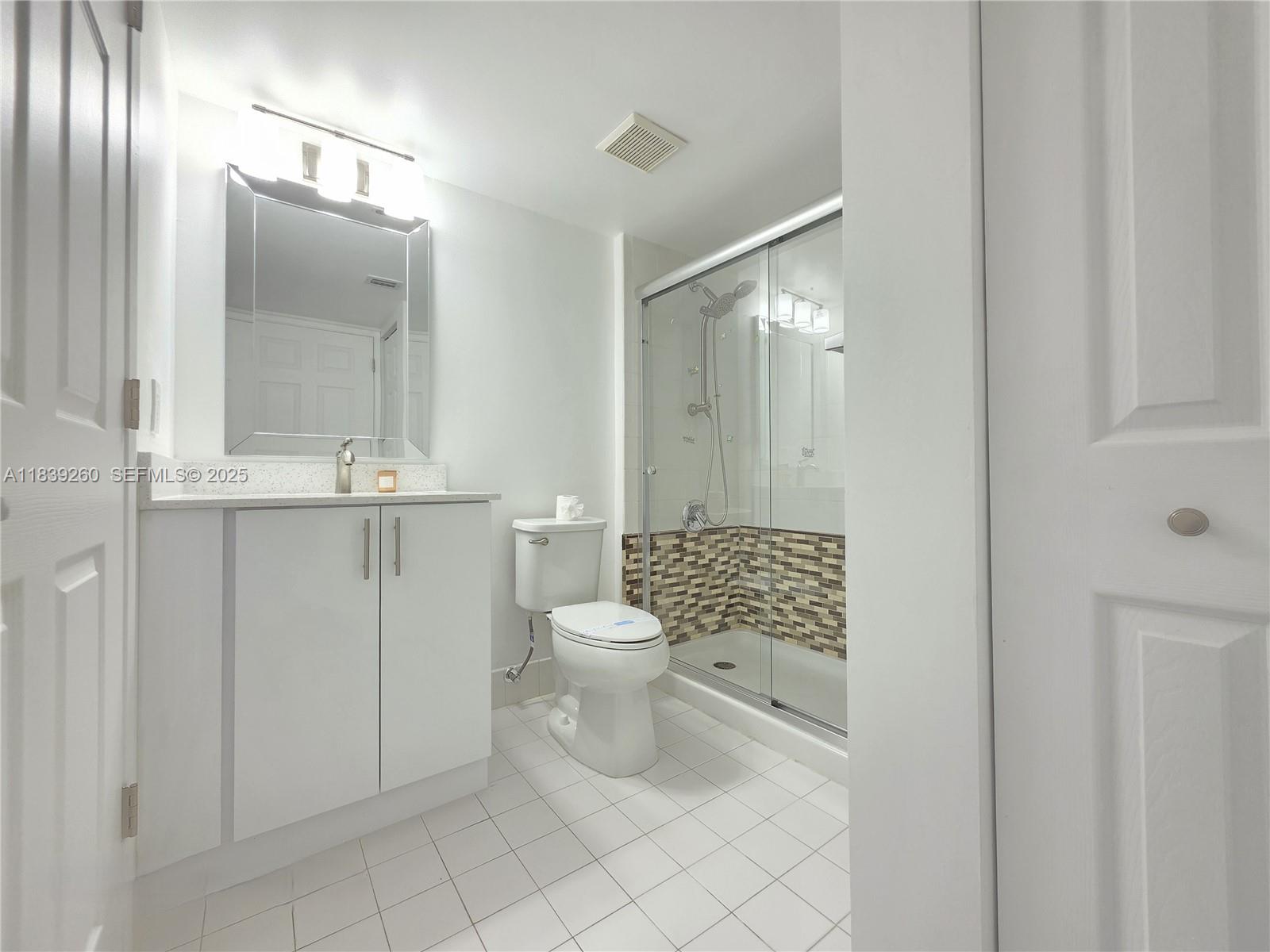 2620 South University Drive, Unit 111 Davie, FL 33328 - Photo 31 of 49 a bathroom with a toilet a sink and mirror