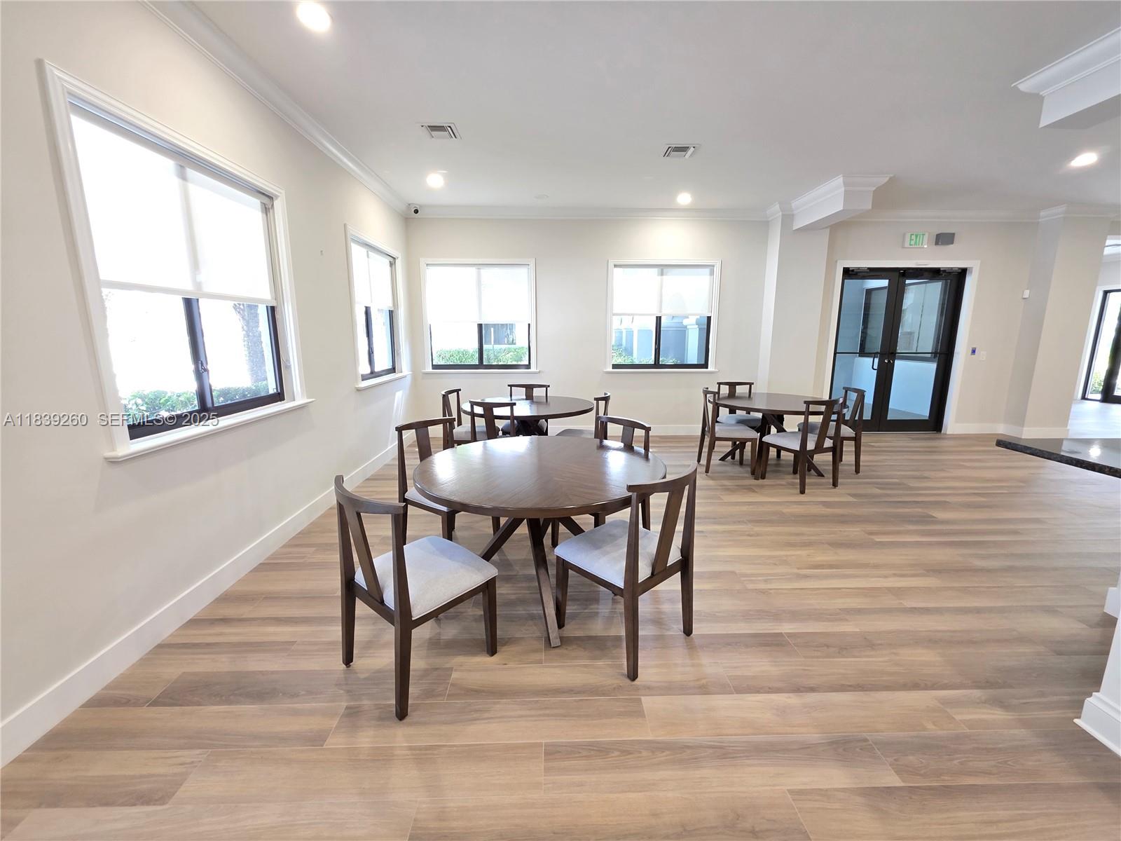 2620 South University Drive, Unit 111 Davie, FL 33328 - Photo 37 of 49 a dining room with wooden floor a glass table and chairs