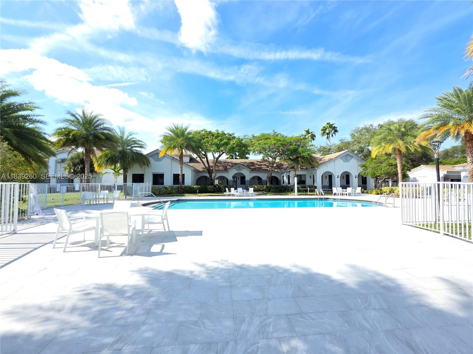 2620 South University Drive, Unit 111 Davie, FL 33328 - Photo 46 of 49 a view of swimming pool with outdoor seating and city in the background