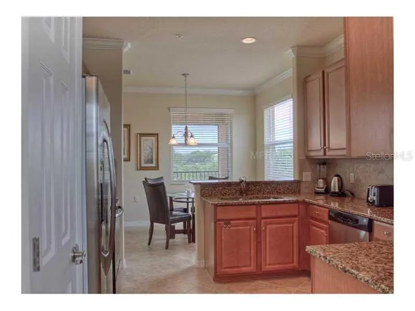 a kitchen with granite countertop a sink cabinets and stainless steel appliances