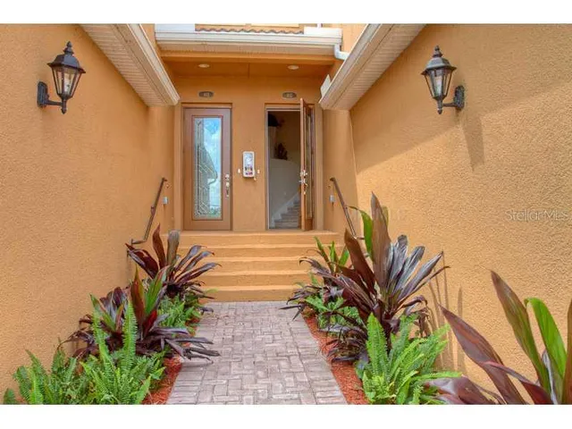 a view of a house with a small yard and potted plants
