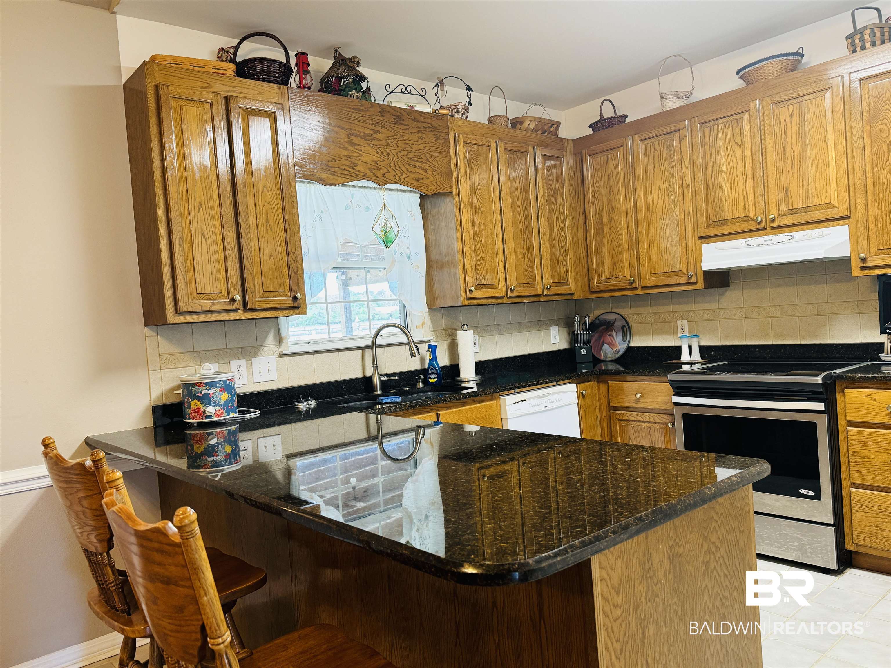13795 White Road Silverhill, AL 36576 - Photo 30 of 99 Kitchen with wood finish cabinets, decorative backsplash, electric stove, a breakfast bar, and dark stone countertops
