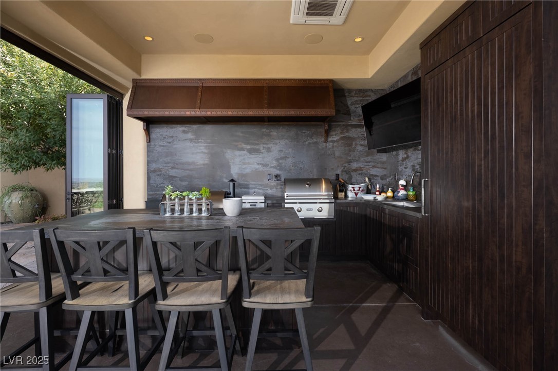 1123 Christian Road Henderson, NV 89002 - Photo 11 of 83 OUTDOOR Kitchen featuring recessed lighting, speakers, dark brown cabinetry, visible vents, and a sink