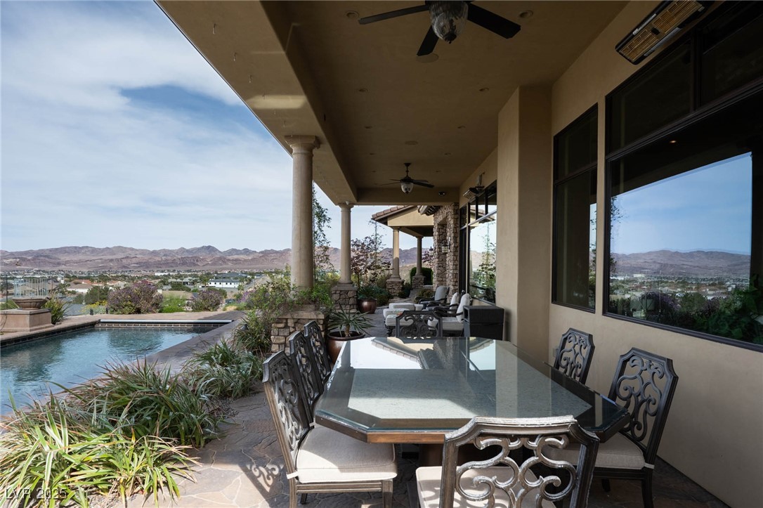 1123 Christian Road Henderson, NV 89002 - Photo 13 of 83 View of patio / terrace with an outdoor pool, a mountain view, ceiling fan, heaters, and outdoor dining area