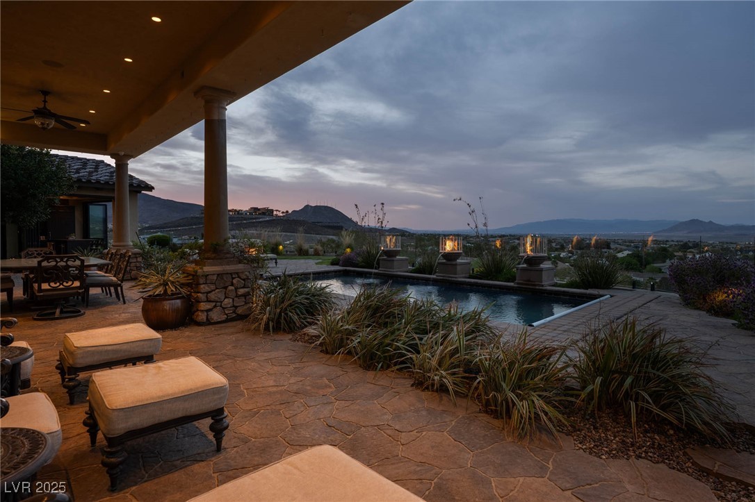 1123 Christian Road Henderson, NV 89002 - Photo 26 of 83 Patio terrace at dusk featuring an outdoor pool, a mountain view, fans, misters, and commercial heaters