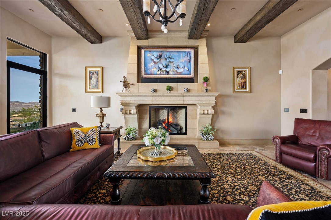 1123 Christian Road Henderson, NV 89002 - Photo 35 of 83 Living area with a substantial fireplace, beamed ceiling, stone baseboards, and valley views