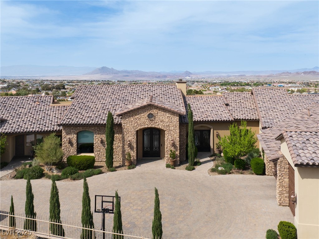 1123 Christian Road Henderson, NV 89002 - Photo 81 of 83 Ranch-style house with stucco siding, stone siding, a mountain view, and a tile roof