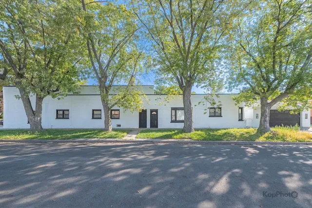 a front view of a house with a yard and trees