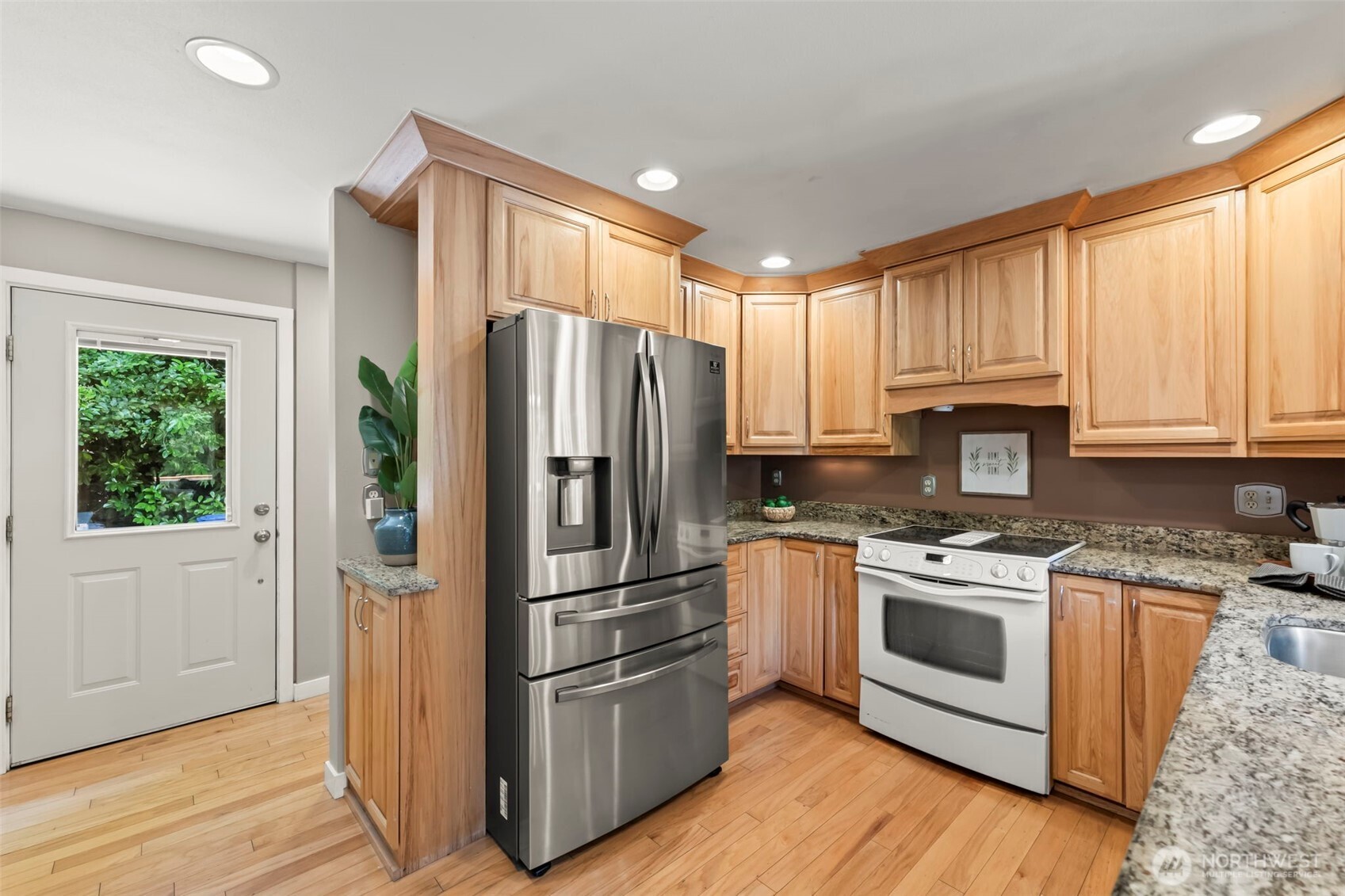 12170 Viewcrest Place Northeast Bainbridge Island, WA 98110 - Photo 11 of 37 a kitchen with wooden floors and stainless steel appliances