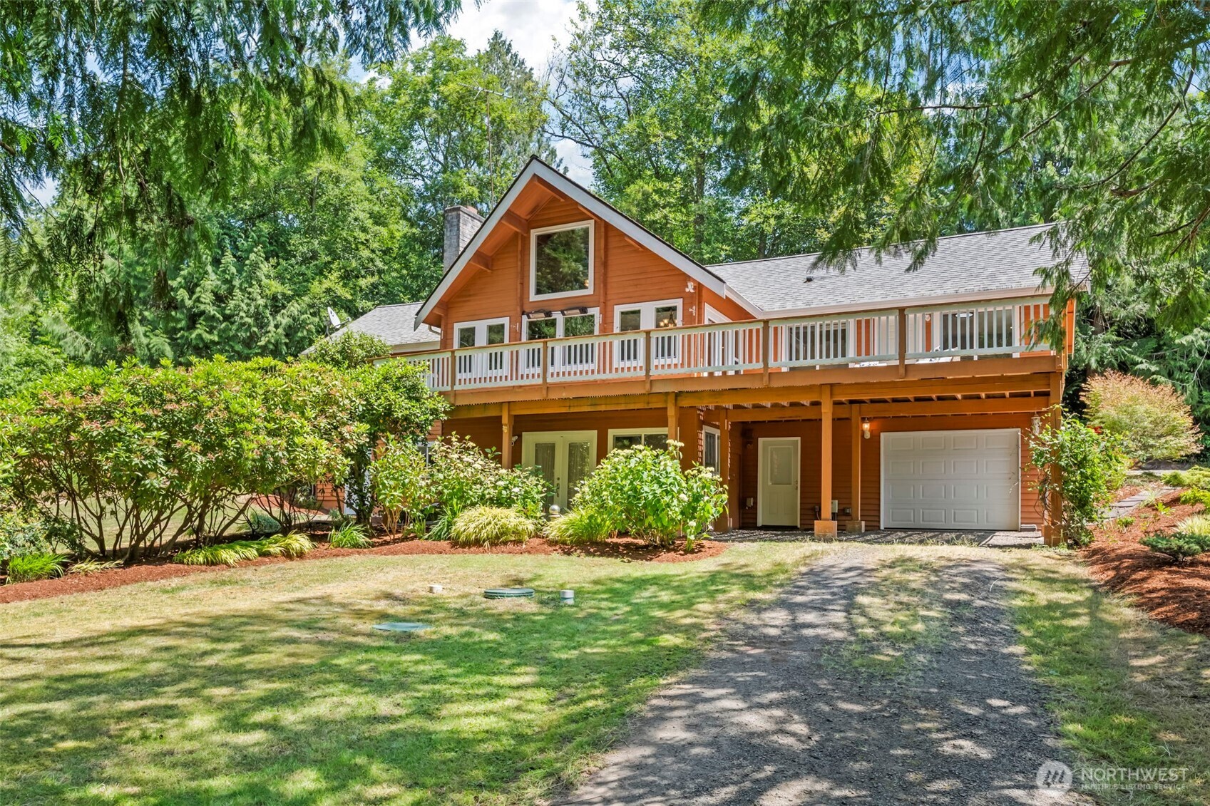 12170 Viewcrest Place Northeast Bainbridge Island, WA 98110 - Photo 2 of 37 a front view of a house with a yard and trees