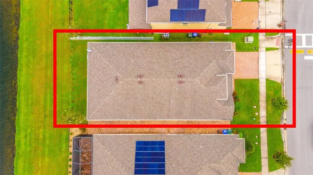 an aerial view of residential houses with outdoor space and lake view