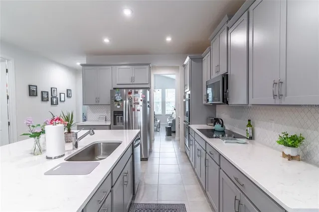 a kitchen with sink a counter space cabinets and appliances