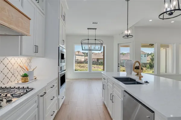 a kitchen with stainless steel appliances granite countertop a sink stove and cabinets