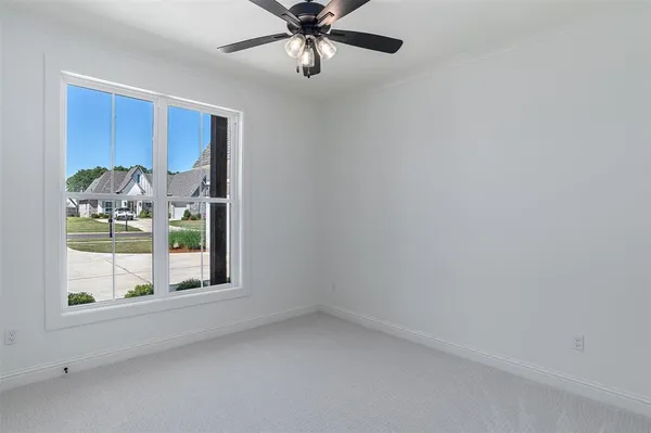 an empty room with chandelier fan
